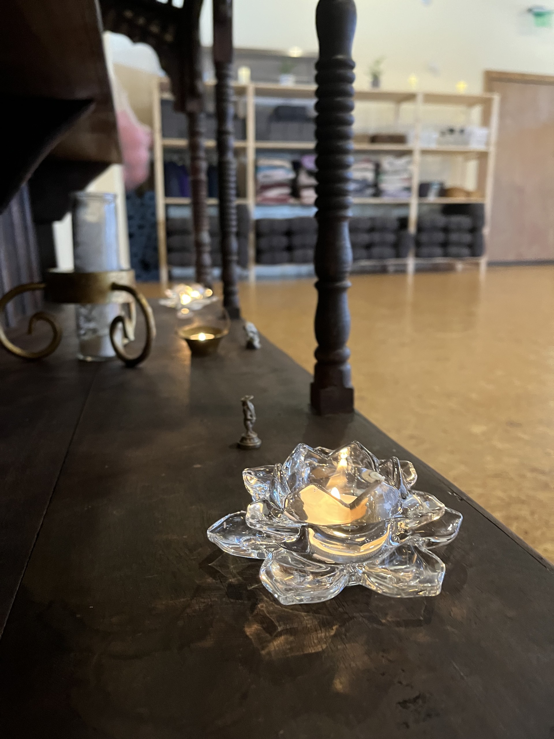 lit candle in glass lotus votive.